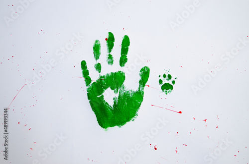 No war text with handprint and dog's paw print on white background,soft focus. Green handprint of human and dog's paw print with red drops photo