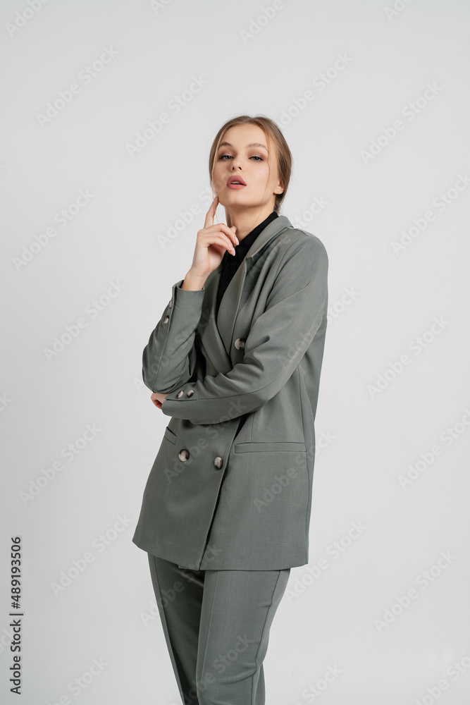 Young lovely girl posing in a business suit. Employee and business concept. Young lovely girl posing in a business suit. Employee and business concept.