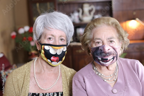 Senior female friends wearing hilarious protective masks
