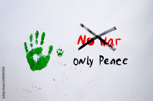 No war text with handprint and dog's paw print on white background,soft focus. Green handprint of human and dog's paw print with red drops photo