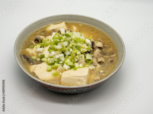 A bowl of shallot, tofu and mushroom soup