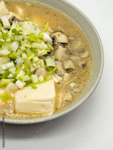 A bowl of shallot, tofu and mushroom soup