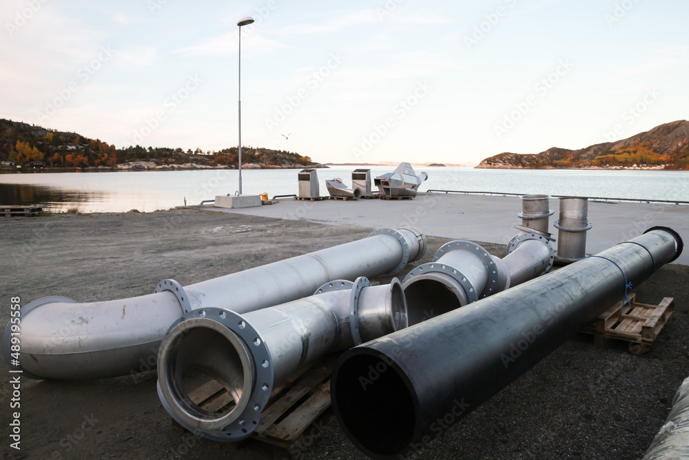Metal pipes lay on the ground of small cargo port Metal pipes lay on the ground of small cargo port