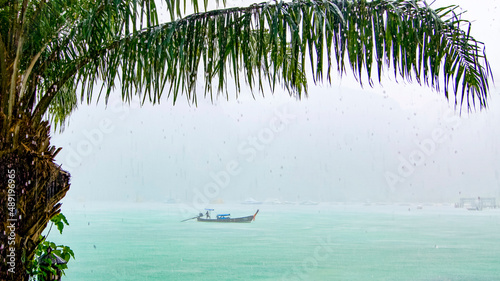 Fototapeta Naklejka Na Ścianę i Meble -  Fisherman is driving with his boat in heavy rain and fog  in the ocean at Kho Pi Pi in Thailand