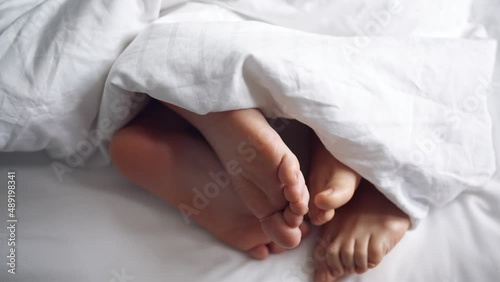 Family couple in bed making love at house, romance woman and man legs togetherness in bedroom. Relationship and intimate of romantic lovers, sexual activity in happy family. naked foot from mattress photo