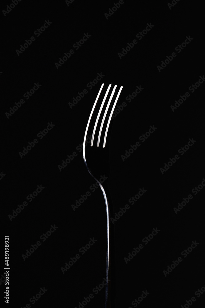 fork on black background. abstract minimalist composition. art object - obrazy, fototapety, plakaty 