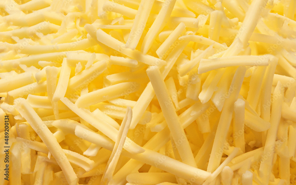 Grated cheese for sandwiches as a background, top view. Cutted cheese closeup. Pattern. Grated cheese for sandwiches as a background, top view. Cutted cheese closeup. Pattern.