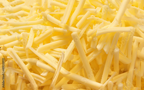 Grated cheese for sandwiches as a background, top view. Cutted cheese closeup. Pattern.