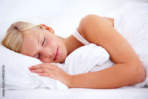 Off to slumberland.... Young woman sleeping comfortably on white linen.