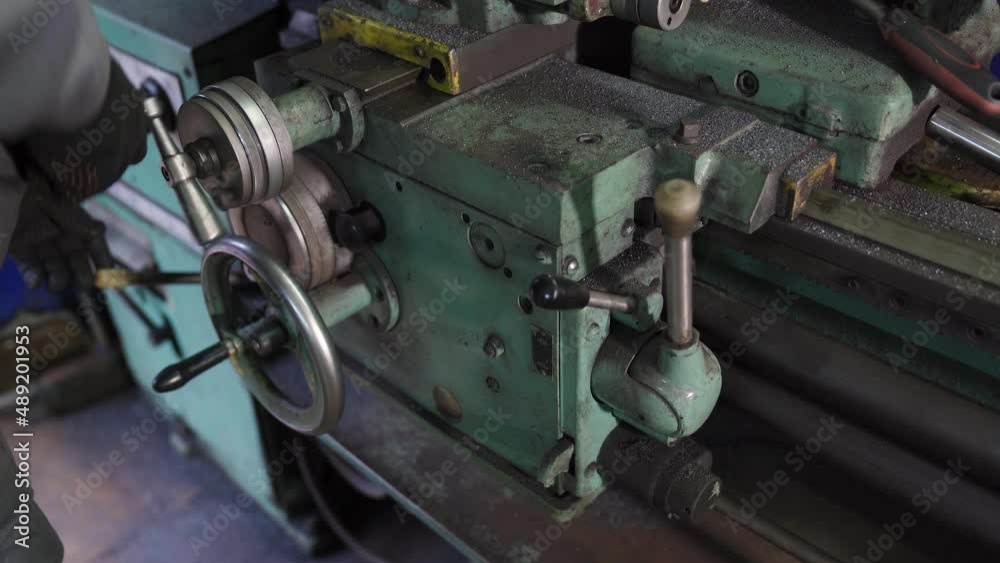 Worker Behind a Lathe Turning an Automotive Part Worker Behind a Lathe Turning an Automotive Part