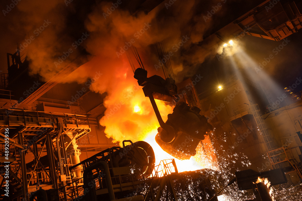 The molten metal is poured from the ladle into the metallurgical furnace.