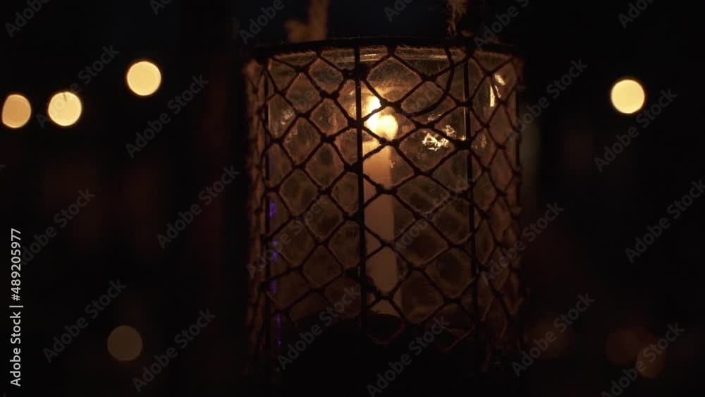 A candle in metal and glass lantern with beautiful bokeh. A candle in metal and glass lantern with beautiful bokeh.