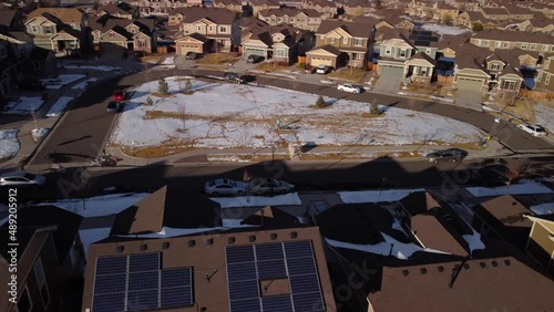 Car leaving snowy Colorado neighborhood during the winter, aerial photo