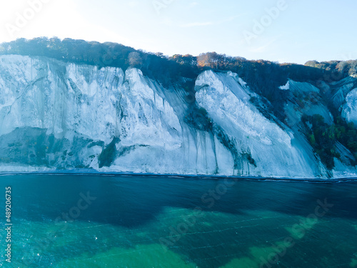 Iconic Møns Klint in Denmark on a sunny autumns day. White chalk cliffs on the Baltic coast aerial photo.