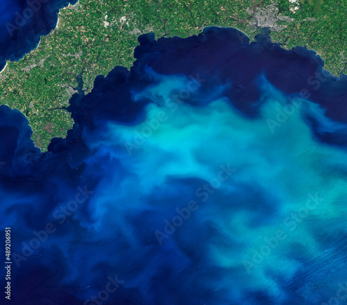 Blooms of phytoplankton in the sea around England, aerial top view photo of blue sea from clear sky, turquoise ocean image background. Elements of this image furnished by NASA.