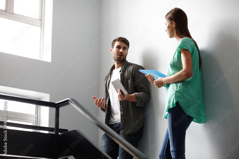 Fototapeta premium Sharing ideas informally. Shot of two people having a conversation in a stairwell.