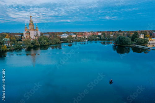 Panoramic aerial view of Holgin pond and islands in Peterhof in summer, reflection in the water, blue color of the water, green trees, a fisherman on a rubber boat fishing