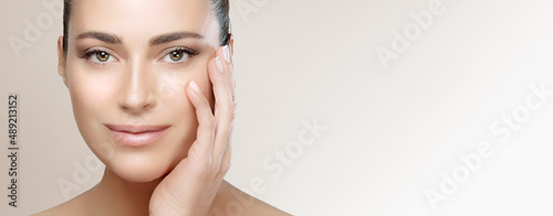 Valokuva Beautiful brunette woman with clean fresh skin touch own face looking at camera