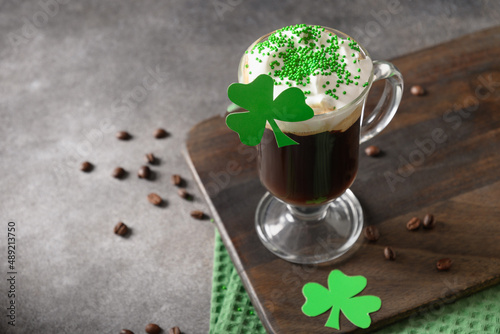 Patrick's Day and celebration with Irish coffee in glass cup with green sprinkles on gray background. Close up. Copy space. photo