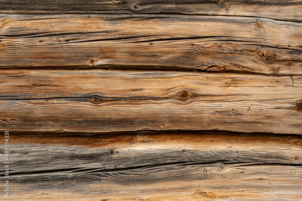 Texture of ancient wooden table surface made with patterned weathered brown boards in rural house yard at bright sunlight extreme close view Texture of ancient wooden table surface made with patterned weathered brown boards in rural house yard at bright sunlight extreme close view