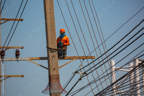 The male worker crane cable car repairs the electric pole.