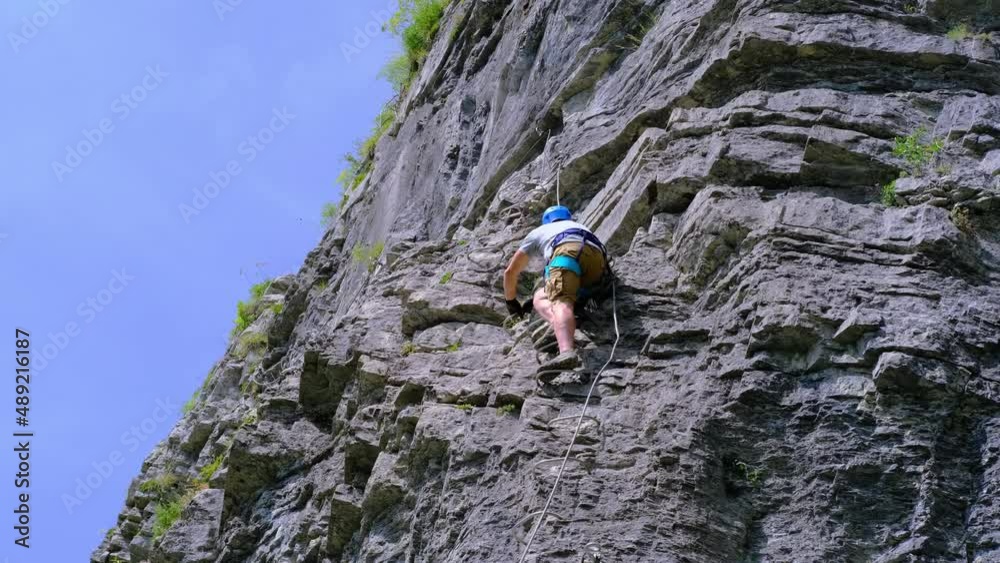 man in body harnesses feature life-safety, attaches hooks to iron brackets, climbs rock, active lifestyle of people, mountaineering, via ferrata in mountains of alps, life insurance in extreme sports man in body harnesses feature life-safety, attaches hooks to iron brackets, climbs rock, active lifestyle of people, mountaineering, via ferrata in mountains of alps, life insurance in extreme sports