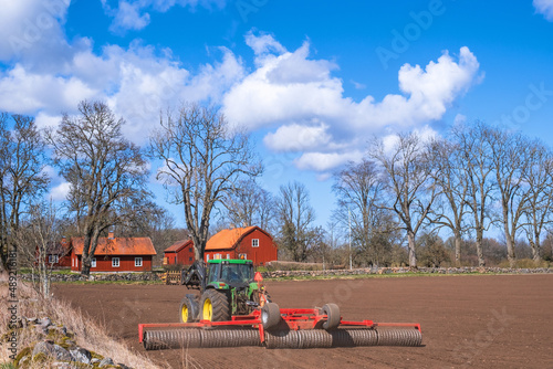 Spring farming with a tractor on a field photo