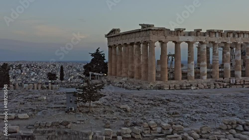 Athens Greece Aerial v32 low level fly around close up shot of ancient ruins of greek parthenon located in city of athens with majestic golden sunset and cityscape in the background - September 2021 photo