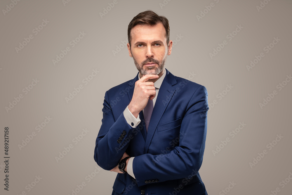 Handsome businessman in elegant suit posing in studio, looking at the camera. Portrait. Copy space. Handsome businessman in elegant suit posing in studio, looking at the camera. Portrait. Copy space.