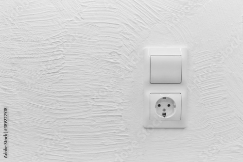 Socket and light off turn on button on the background of the switch white wall of the house, close up