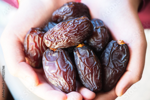 Dried date fruits in a hand. Close up.