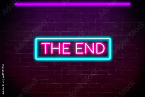 The end neon banner on brick wall background.