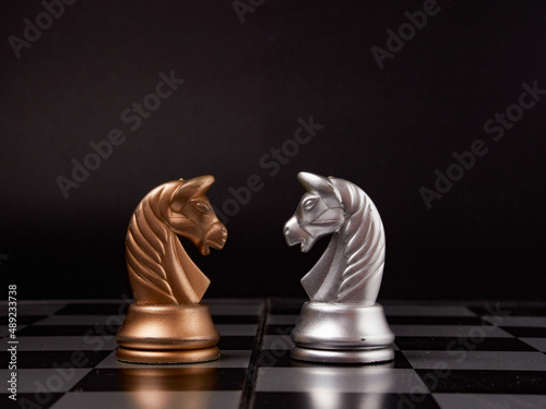 One chess piece stands against a full set of chess pieces. The concept of strategy, planning and decision-making