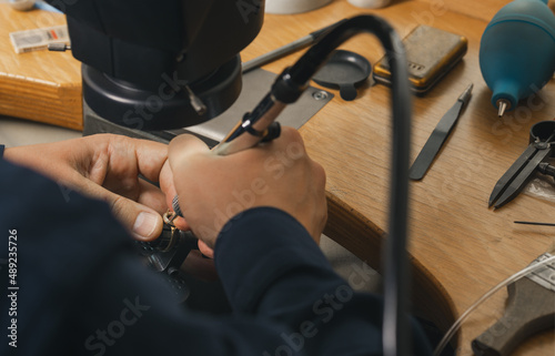 Goldsmith at work. Jeweler s workbenche with different tools. Desktop for craft jewelry making with professional tools.