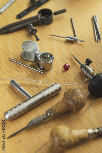 Goldsmith at work. Jeweler's workbenche with different tools. Desktop for craft jewelry making with professional tools.
