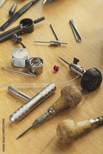 Top view of different goldsmiths engraver tools on the jewelry workplace. Desktop for craft jewelry making with professional tools. Gold jewelry production concept.