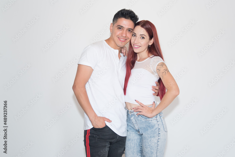 Fototapeta premium embracing couple, smiling, with neutral background, dark-haired boy, red-haired girl
