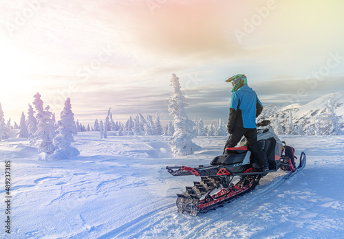 travel on a modern mountain snowmobile against the backdrop of beautiful mountain valleys after a snowfall. Extreme sport adventure, outdoor activity during winter holiday on ski mountain resort