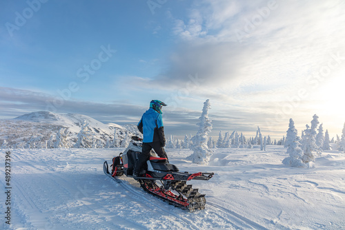 travel on a modern mountain snowmobile against the backdrop of beautiful mountain valleys after a snowfall. Extreme sport adventure, outdoor activity during winter holiday on ski mountain resort