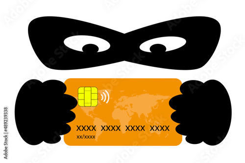 Phishing concept. Thief with a mask behind a credit card. Fraud and theft of bank data