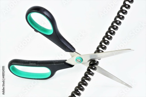 Scissors cutting wire for landline phone communication. It is used inside residential and office premises. The concept of breaking the connection.