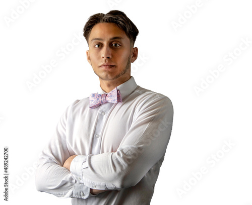 Latin man with confident expression wearing pink bow tie and white shirt against a white background