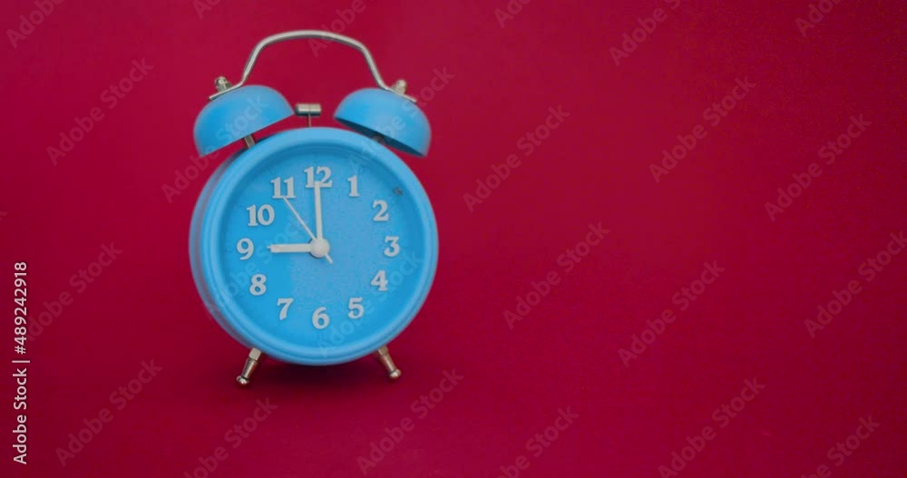 Video with sound - a blue alarm clock on a red background rings at 9 AM Video with sound - a blue alarm clock on a red background rings at 9 AM