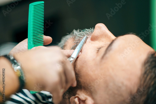 Male customer in a barber shop having a beard trim
