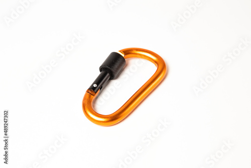 Orange metal carabiner for mountaineering isolated on a white background.
 photo