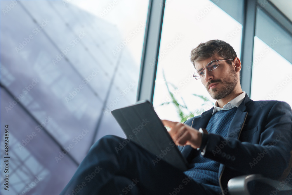 business man using his tablet computer during a trip.