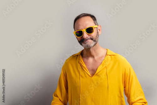 Stylish senior man wearing yellow shit and smiling