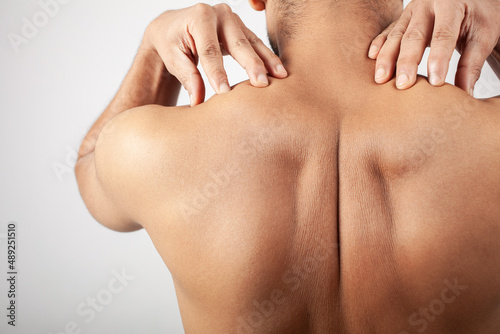trapezius muscle pain, shirtless man showing his shoulder pain