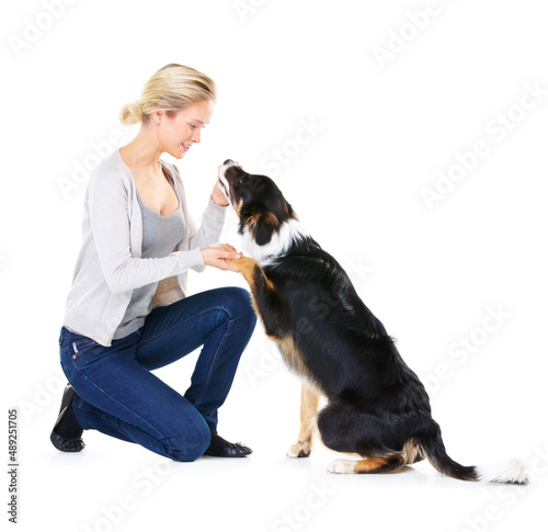 Hes such a good boy. Studio shot of a young woman with her dog isolated on white.