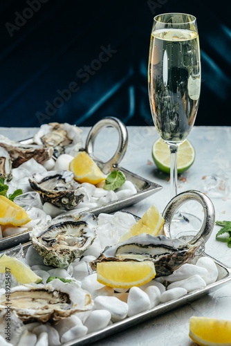 Fresh oysters with lemon and ice. Restaurant delicacy. oysters dish. Oyster dinner with champagne in restaurant, banner, menu, recipe place for text, top view